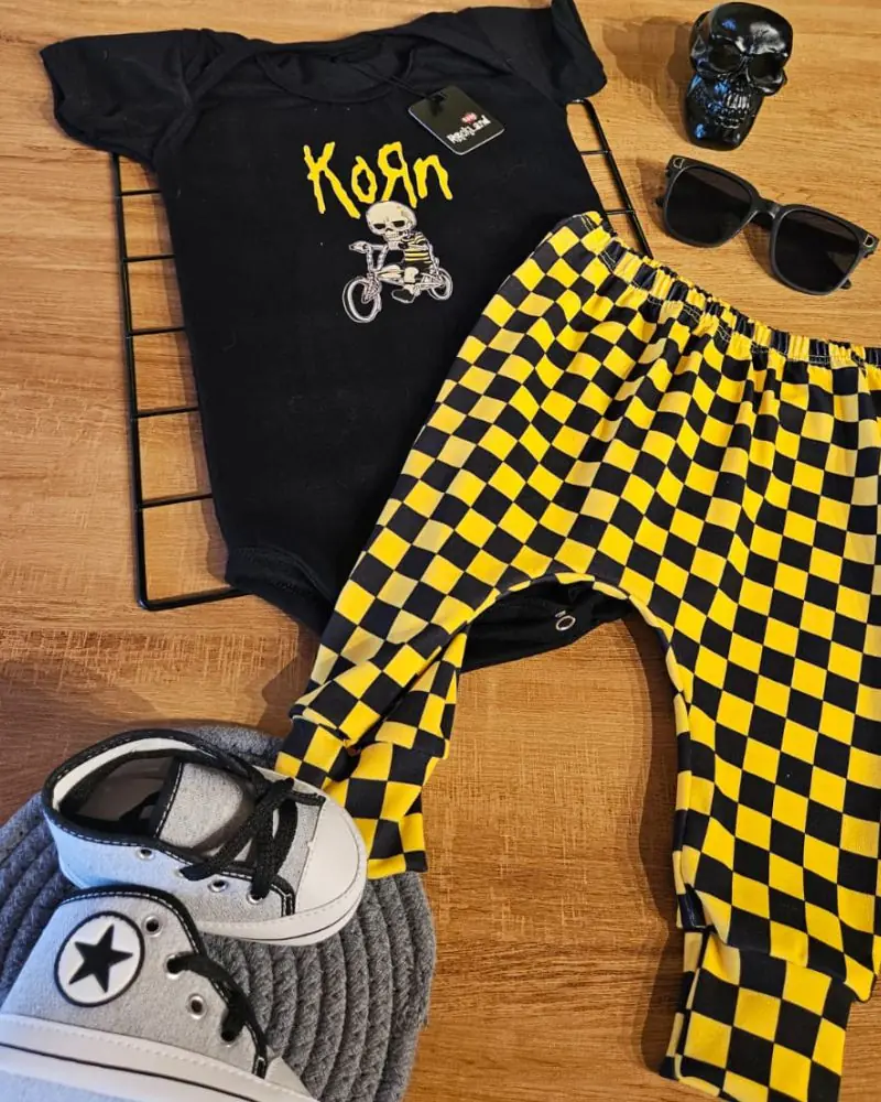 Roupa bebê Korn com body preto, calça xadrez amarela, sapatinho e óculos